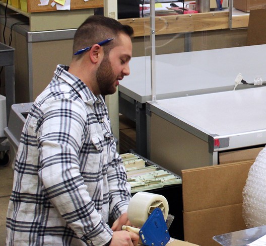 EMS employee taping a box shut