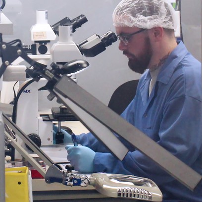 Scientist taking notes next to a microscope